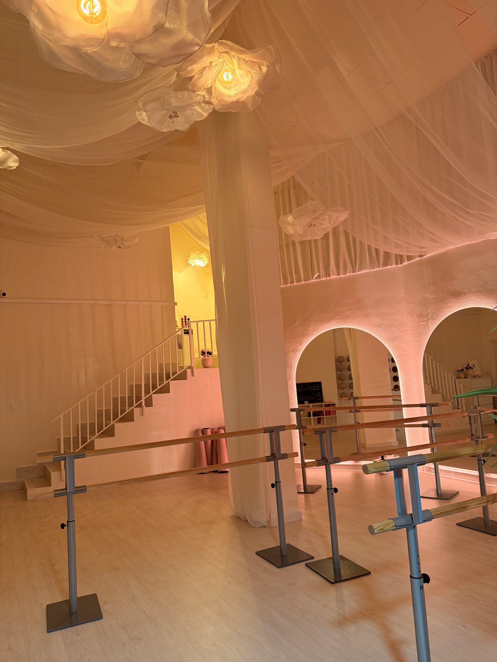 Estudio de Barre con luz cálida, arcos y telas del techo