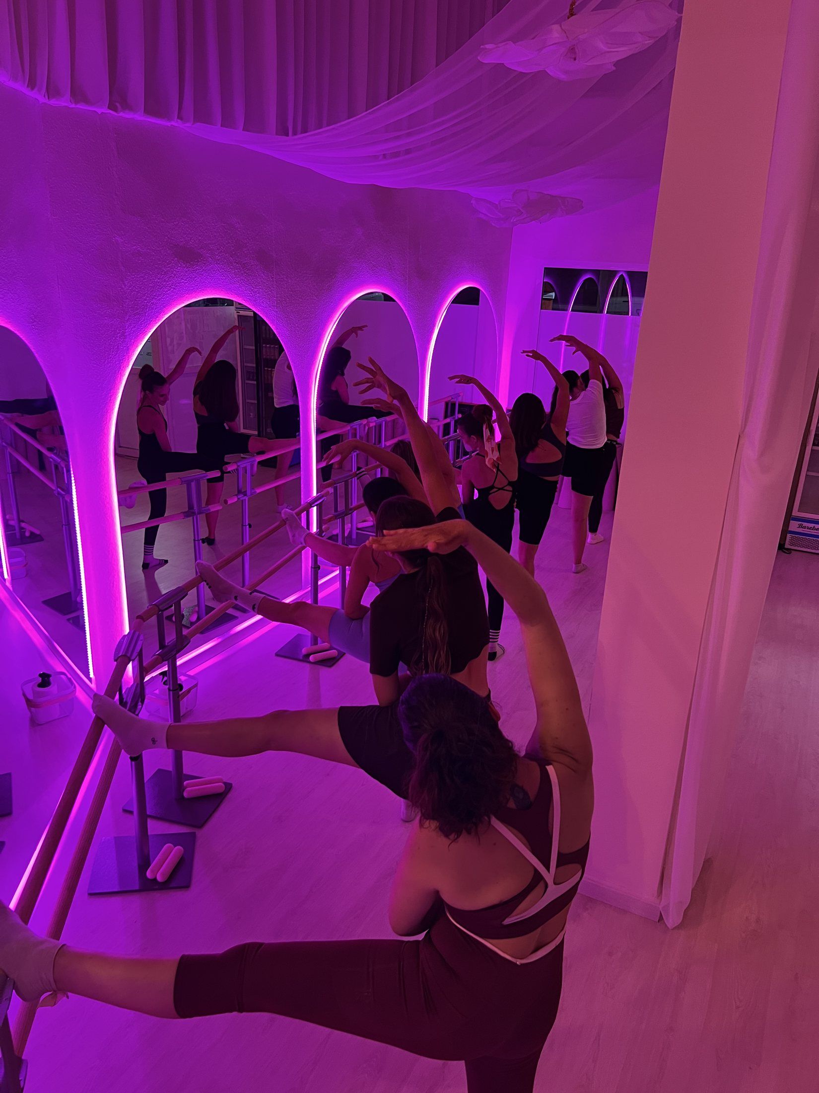 Estiramiento en la barra bajo la luz magenta