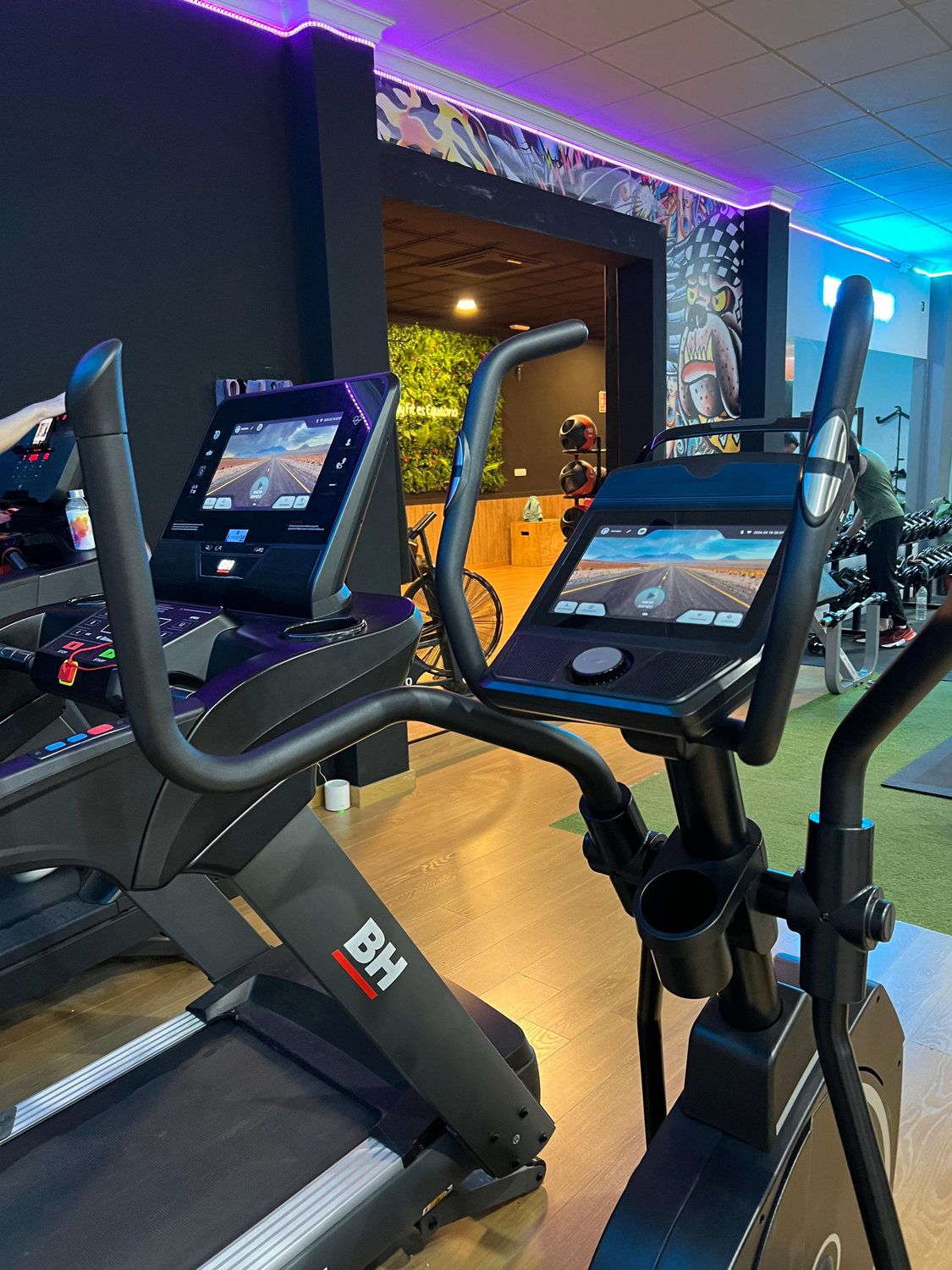 Cintas y bicicletas de la zona de cardio con luz azul