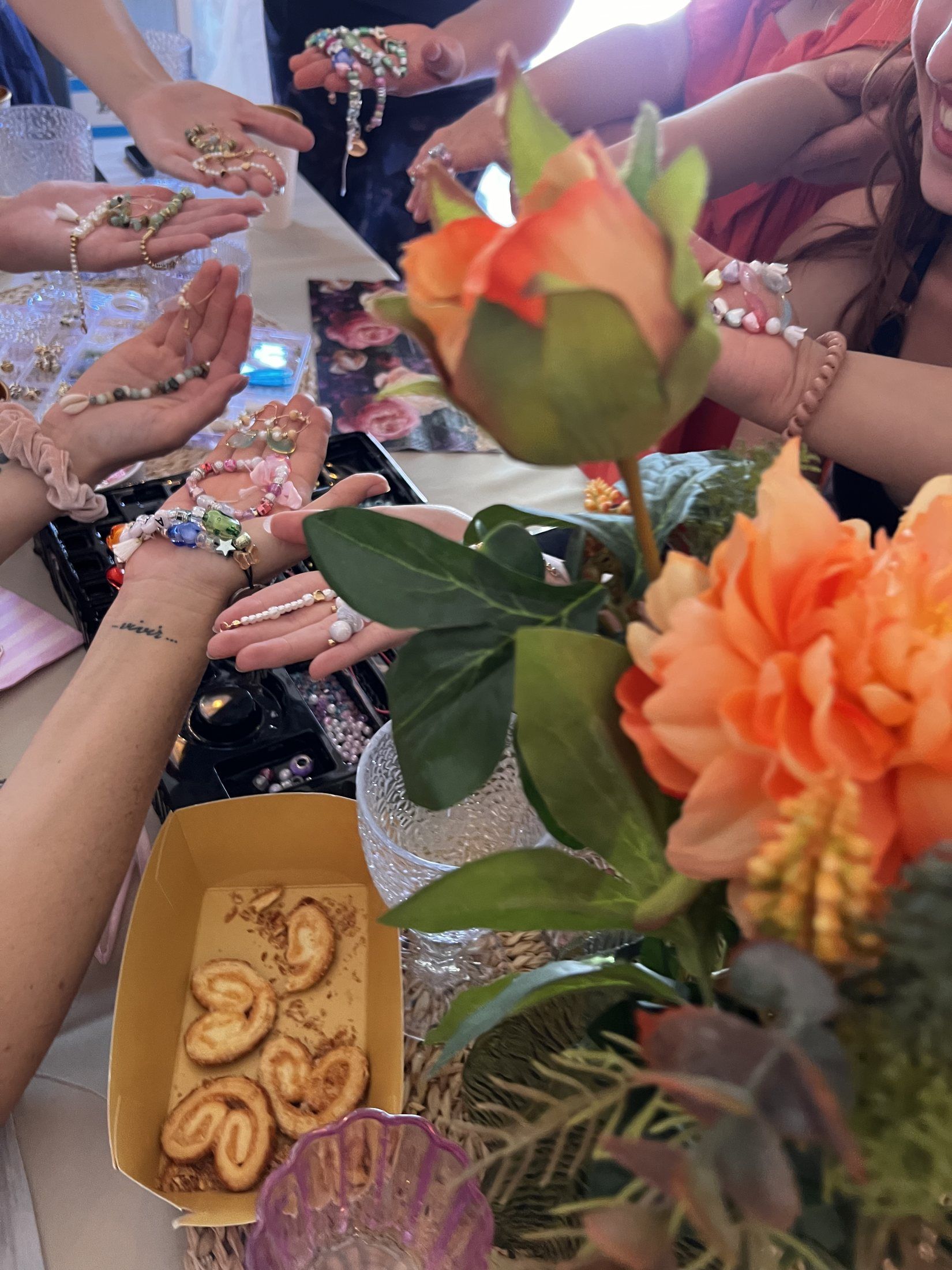 Detalle de las manos con abalorios y flores en el taller