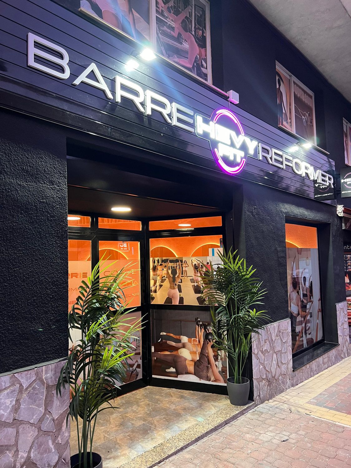 Fachada del estudio de Barre de noche, con el rótulo iluminado