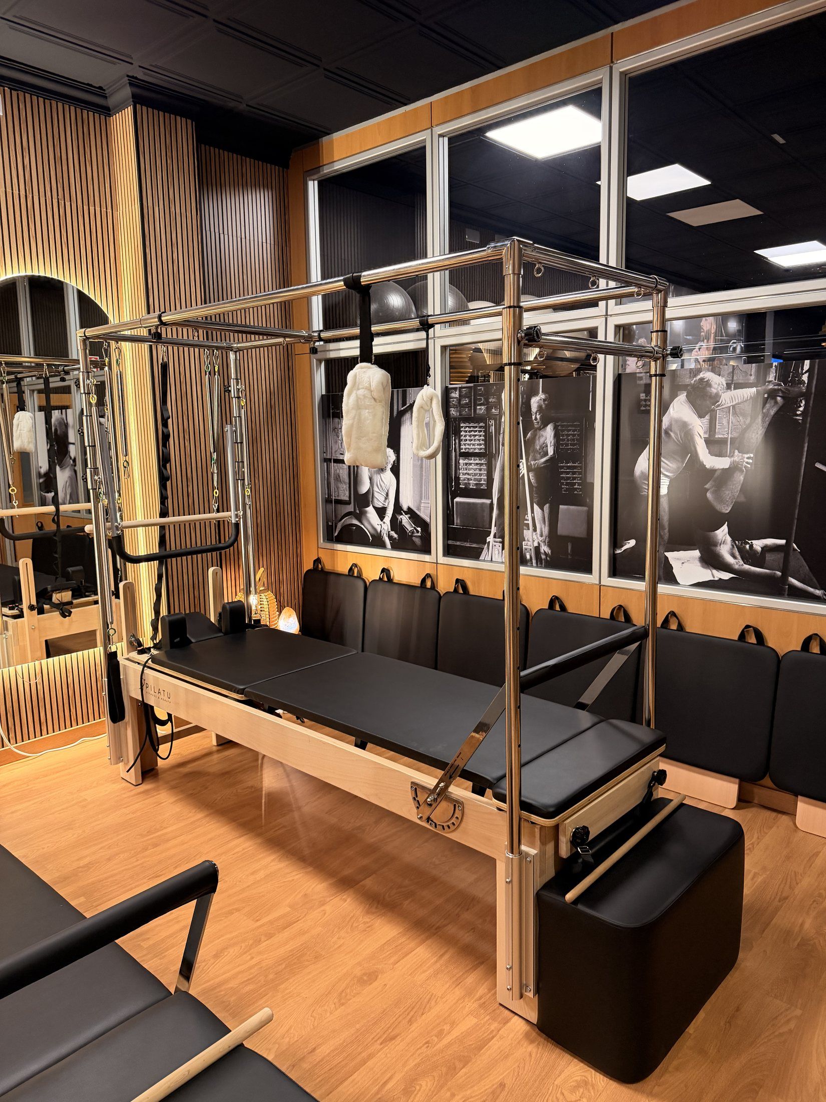 Cadillac y reformer de madera con la pared de fotos antiguas al fondo
